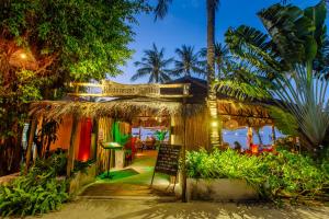 a restaurant with a sign in front of a palm tree at Secret Garden Beach Resort in Bangrak Beach
