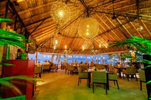a restaurant with tables and chairs and a view of the ocean at Secret Garden Beach Resort in Bangrak Beach