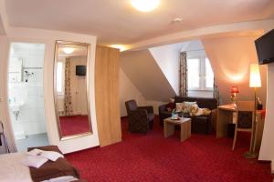 a hotel room with a bed and a bathroom at Boutiquehotel Goldene Rose - self-check-in in Rothenburg ob der Tauber