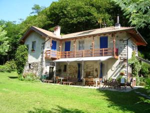 une grande maison en pierre avec une terrasse sur une pelouse dans l'établissement B&B Melizio, à San Maurizio dʼOpaglio