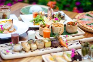a wooden table with plates of food on it at Secret Garden Beach Resort in Bangrak Beach
