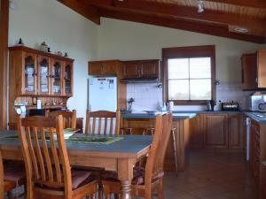 a kitchen with a table and chairs and a refrigerator at Lantauanan - The Lookout in Island Beach