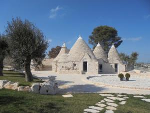 um grande edifício com torres no topo de um quintal em Trulli Resort em Alberobello