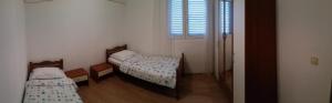 a small room with two beds and a window at Ivanka Apartment in Kaštela