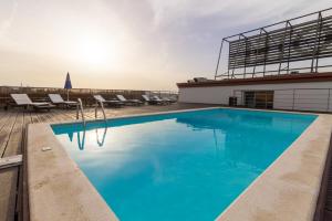 a large blue swimming pool on top of a building at Eurosol Residence Hotel Apartamento in Leiria