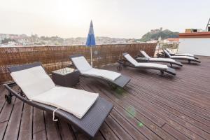 une rangée de chaises sur une terrasse avec un parasol dans l'établissement Eurosol Residence, à Leiria