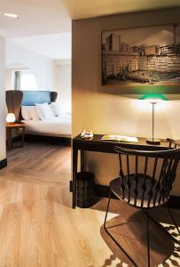 a room with a bed and a desk with a chair at One Shot Luchana in Madrid +46 photos