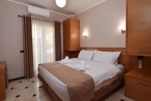 een slaapkamer met een groot bed met witte kussens bij Hotel Pandora Residence in Tirana