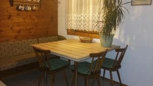 a wooden table with two chairs and a potted plant at Ferienwohnung Waldhäusl in Sankt Martin bei Lofer