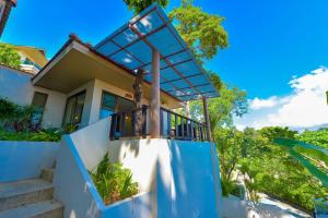 a house with a blue balcony and stairs at Sita Beach Resort in Ko Lipe
