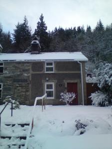 a house with snow on the roof of it at Llugwy Cottage in Betws-y-coed