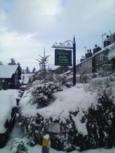 a street sign in the snow on a street at Llugwy Cottage in Betws-y-coed