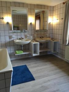 a bathroom with two sinks and two mirrors at On Schopp in Herresbach