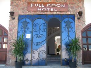an entrance to a full moon hotel with two potted plants at Full Moon in Dahab