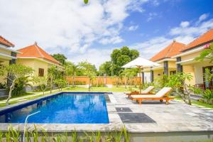 a swimming pool in the backyard of a villa at Kutuh Manak Guest House in Uluwatu