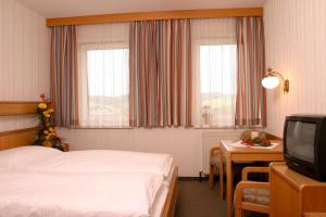 a hotel room with a bed and a television at Gasthof Erzherzog Franz Ferdinand in Sankt Florian bei Linz