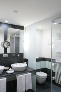 a bathroom with a sink and a toilet and a mirror at Hotel Maximilian in Oberammergau