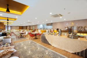 a restaurant with tables and chairs and a bar at Verse Hotel Cirebon in Cirebon