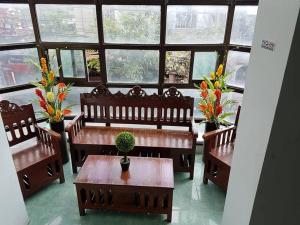 a room with benches and a table with a potted plant at N&J Lopez Lodging House in Manila