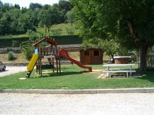 un parque infantil con un tobogán y un banco en un parque en Cà Del Ponte en Costermano