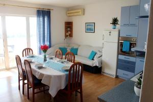 a kitchen and dining room with a table and chairs at Apartment Teraferma in Komiža