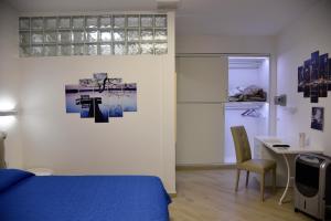 a bedroom with a blue bed and a desk and a table at B&B Quintino Sella in Iglesias