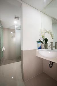 a bathroom with a sink and a glass shower at Verse Hotel Cirebon in Cirebon