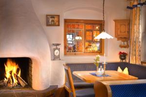 a living room with a fireplace and a table and a dining room at Aparthotel Spitzer in Sankt Gallenkirch