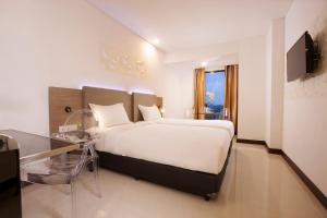a bedroom with a large bed and a glass table at Verse Hotel Cirebon in Cirebon