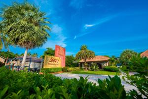 a palm tree in front of a building with a sign at Sita Beach Resort in Ko Lipe