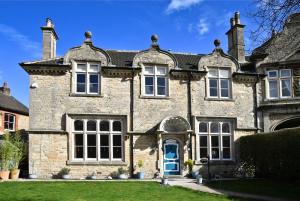 uma velha casa de pedra com uma porta azul em Heritage Bed and Breakfast em Calne