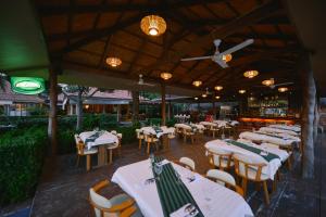 a restaurant with white tables and chairs and a bar at Sita Beach Resort in Ko Lipe