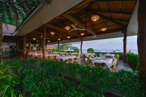 a restaurant with tables and chairs under a pavilion at Sita Beach Resort in Ko Lipe