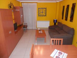sala de estar con sofá y mesa en Apartamentos Monte Hernanz en Riaza