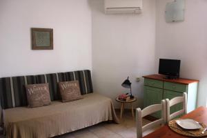 a small room with a bed and a desk with a television at Apartamentos Timon - Emar Hotels in Es Pujols