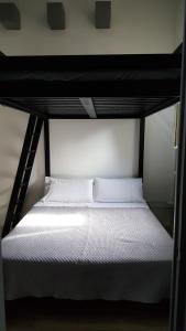 a bunk bed with white sheets and pillows on it at La Gnostra in Altamura