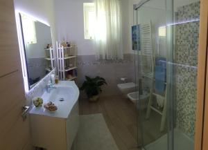 a bathroom with a sink and a shower and a toilet at Mimosa Apartments in Soiano del Lago