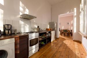 kuchnia z białymi urządzeniami i drewnianą podłogą w obiekcie Forum Sopot w mieście Sopot