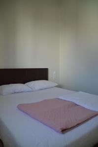 ハニア・タウンにあるChristini Apartmentの白いベッド(ピンクの毛布付)