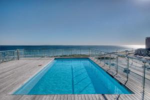 a swimming pool on a deck next to the ocean at Horizon Bay 1404 in Bloubergstrand