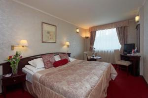 una habitación de hotel con una cama y un escritorio en Capitol Hotel, en Varna