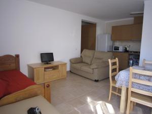 a living room with a bed a couch and a kitchen at casa d'Azoia in Sesimbra