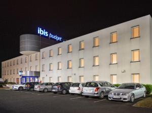 cars parked in front of a large building at Ibis budget Orléans Sud Comet in Orléans