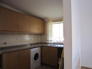 a kitchen with a sink and a washing machine at casa d'Azoia in Sesimbra