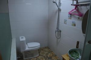 Un pequeño baño con inodoro y ducha. en Yangjiajie Inn, en Zhangjiajie