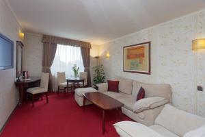 una sala de estar con un sofá y una mesa en Capitol Hotel, en Varna