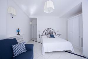 une chambre blanche avec un lit et une chaise dans l'établissement La Valle Delle Ferriere, à Amalfi
