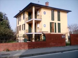 a large white house with a red brick fence at Locanda i Tarocchi in Vailate