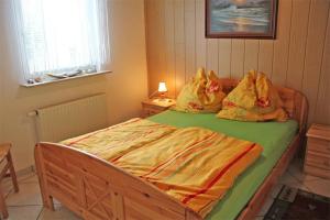 バンシンにあるFerienhaus Bansin USE 2750のベッド(緑色の掛け布団、枕付)