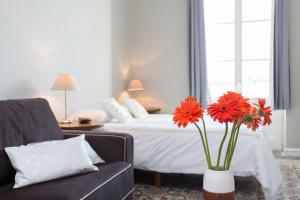 Un dormitorio con una cama y un jarrón con flores. en Palacio de Daoiz lofts, en Santa Cruz de Tenerife